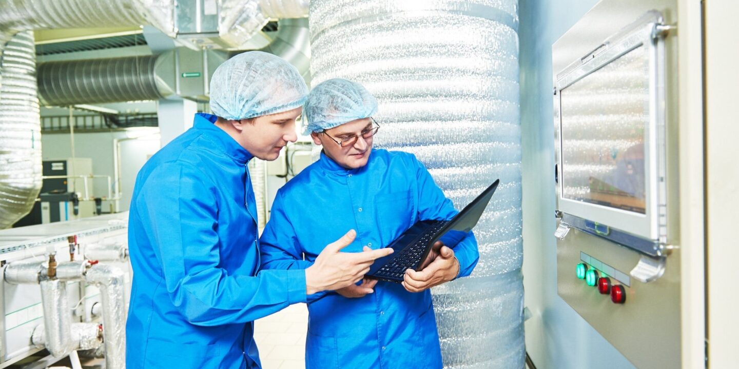 Two men using a laptop in factory - Pre-Inspection Audits Can Help You Prepare for Regulatory Inspections | NSF